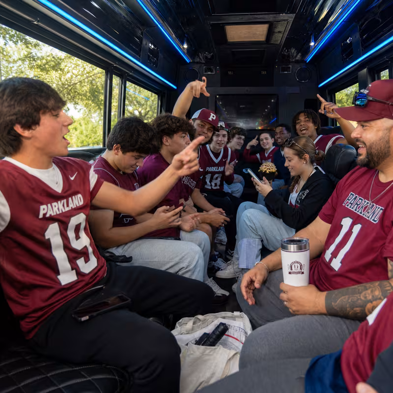 Group boarding a white charter bus for Sporting Event Transportation transportation in Parkland